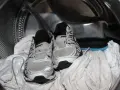 Scarpe da ginnastica pronte per essere lavate in lavatrice, insieme ad alcuni asciugamani bianchi.