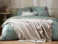 Lit douillet avec housse de couette vert sauge et jeté texturé beige. Quel tissu pour housse de couette ? Le coton doux est idéal.