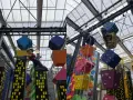 Kinder klettern auf bunte Würfel und Wolkenkratzer in einer Kletterhalle, die an einen Magic Mountain Berlin erinnert.