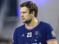 Piłkarz ręczny PSG z numerem 21 na koszulce, skupiony na grze.