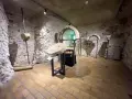 Wnętrze klasztoru w Tyńcu. Kamienne ściany, łuki i artefakty tworzą atmosferę historii.
