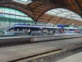 Nowoczesny pociąg kraków wrocław na peronie, pasażerowie czekają na podróż pod zabytkowym zadaszeniem dworca.