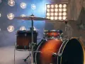 Zestaw perkusyjny dla początkujących w dymie, oświetlony reflektorami. Idealny do nauki gry na instrumencie.