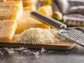 Tarta z serem, gdzie zamiast parmezanu użyto mozzarelli, przygotowana na desce z tarką.