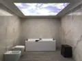 Bagno moderno con vasca, bidet e WC. Il soffitto in cartongesso riproduce un cielo azzurro con nuvole, creando un'atmosfera rilassante.