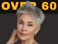 Donna con un elegante corto taglio capelli over 60, sguardo intenso e un sorriso accennato.