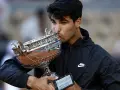 Joven tenista besa el trofeo de Roland Garros, un sueño cumplido y un paso más hacia los grandes premios Grand Slam.