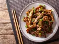Pyszny kurczak teriyaki z sezamem i szczypiorkiem, gotowy do jedzenia pałeczkami.