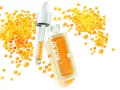 BiolIQ intensywne serum rewitalizujące w buteleczce z pipetą, otoczone kropelkami o pomarańczowym odcieniu.
