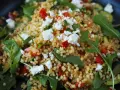 Ein bunter Couscous-Salat mit Feta, roten Paprikawürfeln und Rucola. Frisch und lecker!