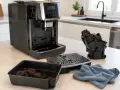 Czyszczenie ekspresu DeLonghi. W tacce resztki kawy, obok wyjęty moduł zaparzający i tacka ociekowa. Czas na świeżą, nie wodnistą kawę.