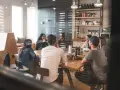 Grupa ludzi przy stole, dyskutująca o tym, co to jest promesa.