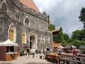 Kamienny zamek Grodziec z gotyckimi oknami, dziedziniec z kramami i ławami. Wiele osób zwiedza to miejsce, a opinie o zamku Grodziec są pozytywne.