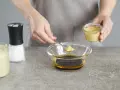 Senf wird zu einer Schüssel mit Öl und Balsamico-Dressing gegeben.