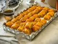 Ein Tablett voller goldbrauner Baklava, bestreut mit Pistazien. Dieses köstliche Baklava-Rezept ist perfekt für jede Feier.