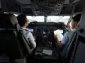 Dwóch pilotów w kokpicie samolotu, dyskutujących o trasie. Ciekawe, ile zarabia pilot Ryanair?