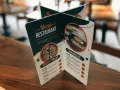 Carta de un restaurante con imágenes de pizza y sándwich. Muestra opciones de menú y precios.