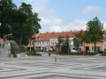Dziecko biega po placu z fontanną, otoczonym kamienicami. To największy rynek w Polsce, tętniący życiem.