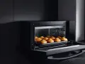 Horno de leña empotrado con bandeja de muffins recién horneados.