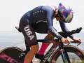 Chloé Dygert, in her USA cycling kit, races against the clock, her focus intense as she powers her bike uphill.
