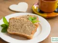 Zwei Scheiben saftiger Becherkuchen mit Joghurt, garniert mit Minze, neben einer Tasse Kaffee.