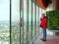Mężczyzna pije kawę, podziwiając panoramę Wrocławia z tarasu widokowego. Sprawdź sky tower wrocław cennik, by poznać ceny biletów.