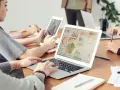 Analityk finansowy pracuje nad raportem na laptopie, analizując wykresy i dane.