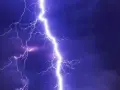 Potężne wyładowanie atmosferyczne rozświetla nocne niebo. Burza może oznaczać problemy, ale pamiętaj o możliwości uzyskania odszkodowanie za brak prądu.