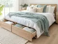 Camas vestidas con encanto, con mantas suaves y cojines acogedores, y cajones de madera para guardar tesoros.