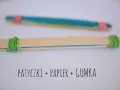 Proste instrumenty muzyczne do zrobienia: patyczki, papier i gumka. Dwa patyczki połączone gumkami, jeden z kolorowym papierem w środku.