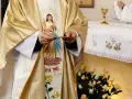 Kapłan w złotej szacie z wizerunkiem Jezusa trzyma hostię. Czy dzisiaj trzeba iść do kościoła?