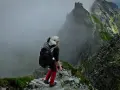 Osoba w kasku i z plecakiem przemierza skalisty szlak. Wspaniała przygoda w górach, prawdziwa turystyka piesza.