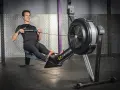 Un homme en tenue de sport effectue un exercice rameur dans une salle de sport.