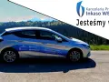 Srebrny samochód Kancelarii Prawnej Inkaso WEC S.A. z napisem "Jesteśmy w terenie!" na tle górskiego krajobrazu.
