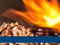 Pellets ardiendo en una estufa, mostrando cuánto consume una estufa de pellets.