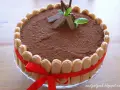 Elegancki tort whisky, udekorowany biszkoptami, kakao i miętą. Czerwona wstążka dodaje mu uroku.
