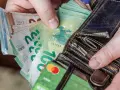 Ręce trzymające euro banknoty i karty płatnicze. Odpowiedź na pytanie: jaka waluta na Litwie? Euro.