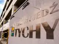 Na ścianie parkingu widnieje napis "PARKUJ I JEDŹ CICHO". Obok znajduje się kolorowy wskaźnik zajętości miejsc. To miejsce, gdzie rejestracja staje się prosta.