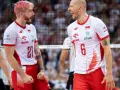 Dwóch zawodników siatkówka polska w biało-czerwonych strojach świętuje punkt. Jeden z różowymi włosami, drugi łysy, obaj krzyczą z radości.
