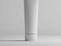 Tubo bianco minimalista, con un sottile anello scuro, che contiene una formula con hydroxypropyl starch phosphate per una pelle liscia.