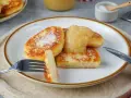 Goldbraune Quarkkeulchen, bestreut mit Zucker, serviert mit Apfelmus. Ein leckeres Quarkkeulchen Rezept zum Genießen.