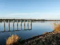 Spokojna tafla wody, pomost i łodzie na rzece tworzą malowniczy krajobraz. To taka kraina z Drohiczynem, gdzie czas płynie wolniej.