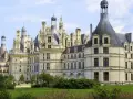 Le château de Chambord, chef-d'œuvre de la Renaissance, se dresse majestueusement sous un ciel bleu. Ses tours et cheminées sculptées rappellent une époque de splendeur.