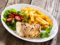 Smażona ryba z frytkami i sałatką z pomidorków. Idealnie, czym przyprawić rybę, by podkreślić jej smak.