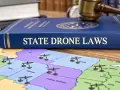 A book titled "State Drone Laws" sits on a map of the US, with miniature drones placed on various states, symbolizing drone regulations across the country, including Iowa.