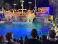 A pirate ship show at Zoomarine Roma with performers on a stage and in the water.