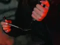 Dłoń trzymająca strzykawkę i łyżkę z płynem, oświetlone czerwonym światłem.