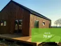 Nowoczesny, drewniany dom do 70m2 bez pozwolenia, z tarasem i dużymi oknami, otoczony zielenią.