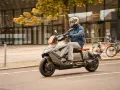 Mężczyzna w kasku jedzie na futurystycznym skuterze BMW CE04 po mieście.