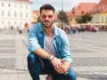 Uomo con occhiali da sole rosa e camicia di jeans, un'idea su come vestirsi in primavera uomo.